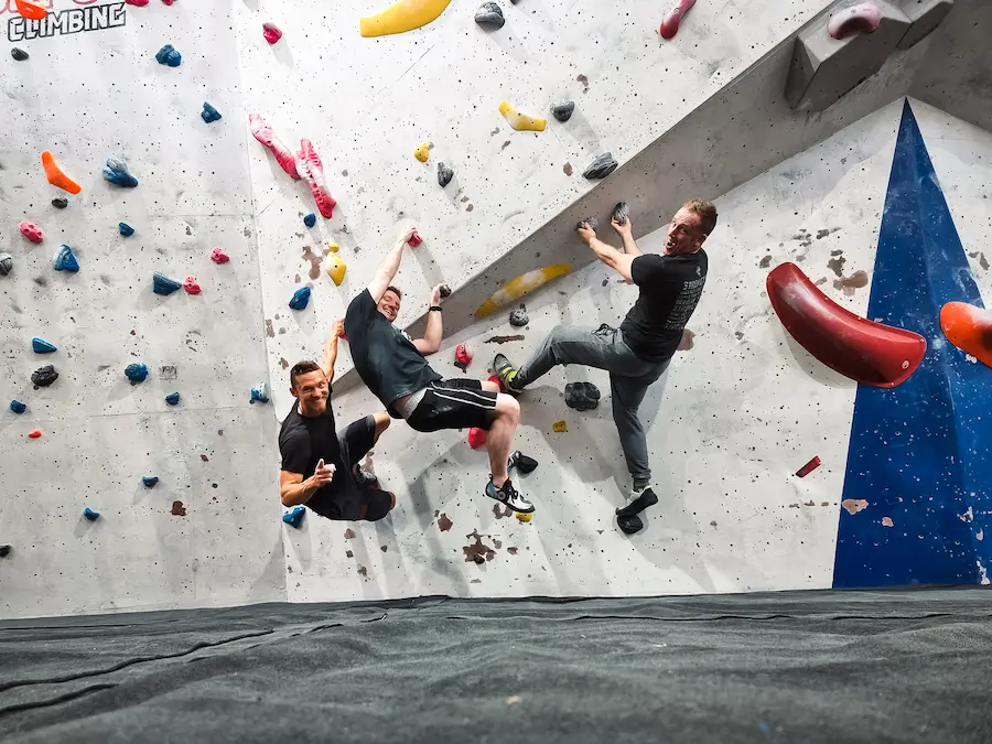 A posed photo of Frankie with two of his friends at in indoor bouldering climbing centre.