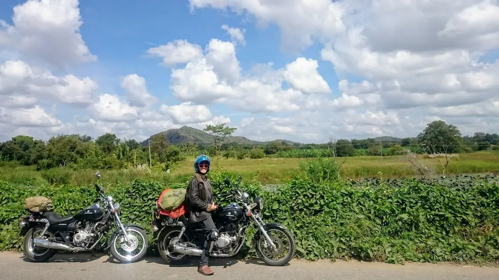 Frankie riding a motorcycle in the greener middle belt of India